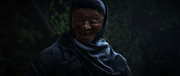 A masked black-robed individual