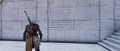 Bayek finding a Greek inscription of a bounty requested by the lanista at the gladiator school