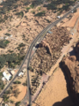 Aerial view of the Old Town and its oasis, separated today by a modern road, with remains of mud brick buildings: tightly packed in the town, and within individual farms and gardens in the oasis.